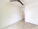 A sunlit bedroom features a ceiling fan, tile floors, and a closet with sliding doors at 25640 N 108Th Dr, Peoria, AZ 85383