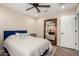 Bright bedroom featuring a ceiling fan, hardwood floors, and a decorative mirror creating a spacious feel at 26391 N 107Th Dr, Peoria, AZ 85383