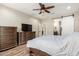 Bedroom features wood-look floors, ceiling fan, and ensuite access with a modern sliding barn door at 26391 N 107Th Dr, Peoria, AZ 85383