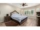 Comfortable bedroom featuring hardwood floors, ceiling fan, and large window for natural light at 26391 N 107Th Dr, Peoria, AZ 85383