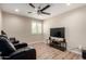A cozy bedroom features a ceiling fan, plantation shutters and a comfy black leather reclining sofa at 26391 N 107Th Dr, Peoria, AZ 85383