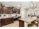 Modern kitchen featuring stainless steel appliances, dark wood cabinets, and a granite countertop island with barstool seating at 26391 N 107Th Dr, Peoria, AZ 85383
