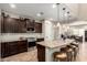 Spacious kitchen featuring dark cabinets, a granite countertop island with seating, and stainless steel appliances at 26391 N 107Th Dr, Peoria, AZ 85383