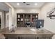 Spacious office featuring a built-in bookshelf, a large desk, and neutral color palette, perfect for working from home at 26391 N 107Th Dr, Peoria, AZ 85383