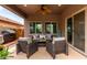 Comfortable covered patio with seating and ceiling fan, perfect for outdoor relaxation and entertaining at 26391 N 107Th Dr, Peoria, AZ 85383