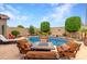 Beautiful backyard oasis featuring a large pool, lounge chairs, and an outdoor seating area with fire pit at 26391 N 107Th Dr, Peoria, AZ 85383