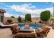 Inviting backyard pool area with comfortable lounge chairs and a tiled fire pit, perfect for outdoor enjoyment at 26391 N 107Th Dr, Peoria, AZ 85383