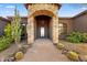 Elegant stone archway entrance features decorative wrought iron door and desert landscaping at 28025 N 156Th Pl, Scottsdale, AZ 85262