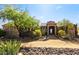Charming stone and stucco home with beautiful desert landscaping and stone archway entrance at 28025 N 156Th Pl, Scottsdale, AZ 85262