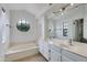 Bright bathroom with a double sink vanity, soaking tub, and a round window at 3315 E Taro Ln, Phoenix, AZ 85050