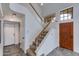 Grand foyer featuring a staircase with wood railings, tile flooring, and a solid wood door at 3315 E Taro Ln, Phoenix, AZ 85050