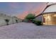 Expansive backyard with gravel landscaping, screened-in porch, and mature trees for shade and privacy at 3443 E Wickieup Ln, Phoenix, AZ 85050