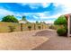 Large backyard with stone landscaping, a privacy wall, mature trees, and desert shrubs at 3443 E Wickieup Ln, Phoenix, AZ 85050