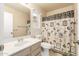 Well-lit bathroom featuring a single vanity, toilet, and shower with a themed shower curtain at 3443 E Wickieup Ln, Phoenix, AZ 85050