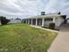 Backyard with green grass, a patio, and a white house with a screened-in porch at 3849 W Mauna Loa Ln, Phoenix, AZ 85053