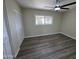 This bedroom features wood floors, a ceiling fan, and a bright window overlooking the outdoors at 3849 W Mauna Loa Ln, Phoenix, AZ 85053