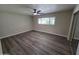 Spacious bedroom with wood-look floors, a ceiling fan, and a large window at 3849 W Mauna Loa Ln, Phoenix, AZ 85053