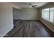 Sunlit living room featuring new wood-look floors and a ceiling fan at 3849 W Mauna Loa Ln, Phoenix, AZ 85053