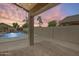 Covered patio provides relaxing area with pool, palms, and waterfall feature; perfect outdoor retreat at 4041 W Hackamore Dr, Phoenix, AZ 85083