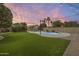 Lush backyard with artificial turf, a pool with waterfall, and desert landscaping; great for relaxing at 4041 W Hackamore Dr, Phoenix, AZ 85083