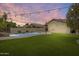 Backyard retreat with pool, manicured grass, and stylish lighting for serene outdoor living at 4041 W Hackamore Dr, Phoenix, AZ 85083