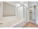 Bright bathroom featuring tub, glass enclosed shower, and access to walk-in closet at 4041 W Hackamore Dr, Phoenix, AZ 85083