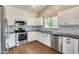 Bright kitchen featuring white cabinets, stainless steel appliances, granite countertops, and a stylish backsplash at 4041 W Hackamore Dr, Phoenix, AZ 85083