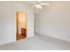 Bright main bedroom featuring neutral carpeting, ceiling fan, and ensuite bathroom entrance at 4041 W Hackamore Dr, Phoenix, AZ 85083