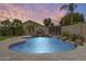 Inviting backyard swimming pool with rock waterfall feature, mature palm trees, and beautiful travertine tile at 4041 W Hackamore Dr, Phoenix, AZ 85083