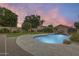Backyard oasis featuring a large swimming pool, a waterfall feature, lush landscaping, and a grassy area at 4041 W Hackamore Dr, Phoenix, AZ 85083