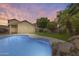 Sparkling pool with rock waterfall and lush landscaping creates serene backyard oasis at 4041 W Hackamore Dr, Phoenix, AZ 85083