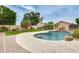 Backyard oasis featuring a large swimming pool, a waterfall feature, lush landscaping, and a grassy area at 4041 W Hackamore Dr, Phoenix, AZ 85083
