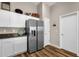 Kitchen cabinets with decor on top of them, stainless steel refrigerator, and two doors at 4332 E Cassia Ln, Gilbert, AZ 85298