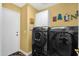 Efficient laundry room with modern black washer and dryer set and yellow walls at 4332 E Cassia Ln, Gilbert, AZ 85298