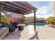 Relaxing backyard with a covered patio, outdoor seating, a sparkling pool, and lush landscaping, creating the perfect retreat at 43615 W Roth Rd, Maricopa, AZ 85138
