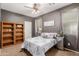Bedroom with neutral decor, featuring a ceiling fan, and a decorative bookshelf at 43615 W Roth Rd, Maricopa, AZ 85138