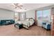 Inviting main bedroom featuring a sitting area, ceiling fan, and expansive windows at 43615 W Roth Rd, Maricopa, AZ 85138