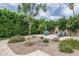 Backyard patio with a custom fireplace, outdoor seating, and landscaped with gravel and plants at 4443 W Acoma Dr, Glendale, AZ 85306