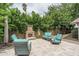 A cozy outdoor space with custom fireplace, comfortable patio seating, and lush landscaping at 4443 W Acoma Dr, Glendale, AZ 85306