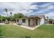 Well-maintained backyard with covered patio, lush green lawn, and mature trees, creating a serene outdoor space at 4443 W Acoma Dr, Glendale, AZ 85306