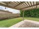 Green backyard featuring a covered patio and greenery at 4443 W Acoma Dr, Glendale, AZ 85306