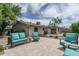 Inviting backyard patio with stylish outdoor seating, lush landscaping, and beautiful travertine tile flooring at 4443 W Acoma Dr, Glendale, AZ 85306