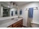Well-lit bathroom with a sink, spacious countertop, and decorative mirrors at 4443 W Acoma Dr, Glendale, AZ 85306