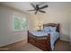 Cozy bedroom featuring a ceiling fan, a comfortable bed with decorative headboard and bright, shuttered windows at 4443 W Acoma Dr, Glendale, AZ 85306