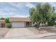 Attractive home exterior with a spacious driveway, well-maintained lawn, and mature trees providing shade and curb appeal at 4443 W Acoma Dr, Glendale, AZ 85306