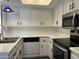 Well-lit kitchen with white cabinets, modern appliances, and functional layout at 461 W Holmes Ave # 271, Mesa, AZ 85210