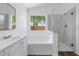 Bright bathroom showcasing a tub, a marble glass shower, and a window offering an outdoor view at 471 W Gascon Rd, San Tan Valley, AZ 85143