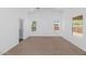 Bright bedroom with carpet flooring, three windows providing natural light and a view of the neighborhood at 471 W Gascon Rd, San Tan Valley, AZ 85143