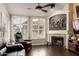 Cozy living room features a stone fireplace, plantation shutters, dark wood floors and a ceiling fan at 500 N Roosevelt Ave # 26, Chandler, AZ 85226