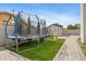 Backyard featuring a trampoline, playground, and green turf for endless outdoor activities at 5020 E Dallas St, Mesa, AZ 85205